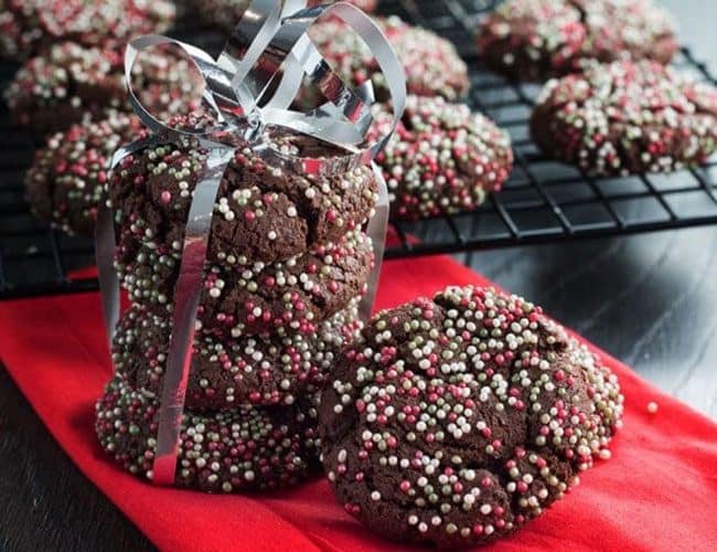 a stack of festive Chocolate Christmas Crinkle Cookies tied together with a ribbon