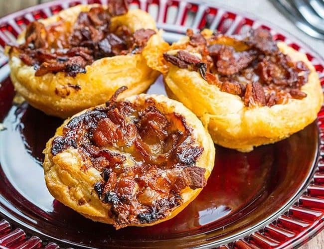 Cranberry Brie Tarts with Bacon & Red Onion on a red serving dish