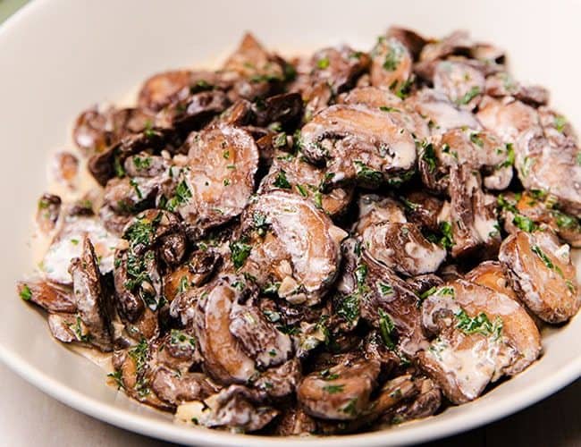 Creamy Garlic Mushrooms in a cream colored serving dish