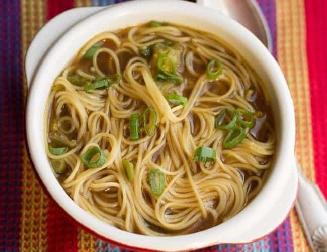 Chinese Noodle Soup in a bowl with sliced green onions on top.