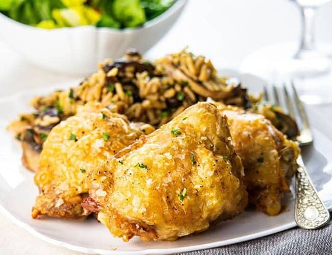 Crispy Oven Baked Chicken Thighs on a plate with some rice