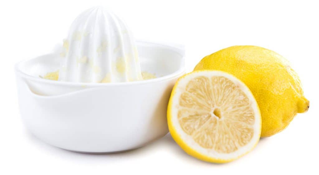 a lemon juicer with two lemon halfs next to it