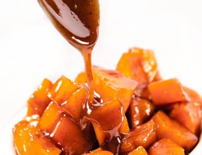 caramel sauce being spooned onto sweet potatoes