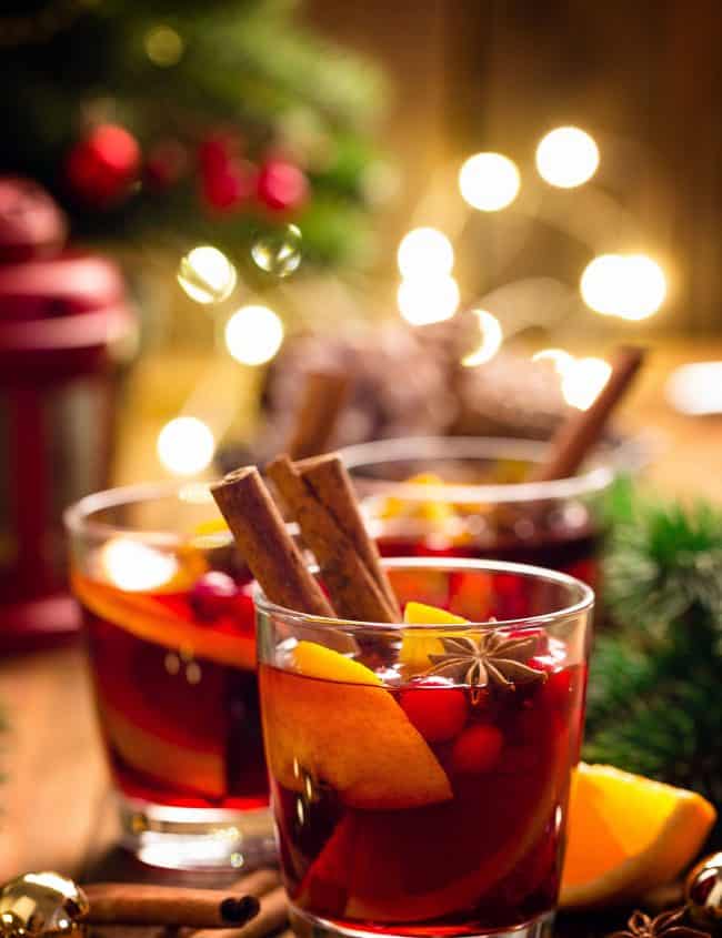 two glasses of Christmas Punch with festive lights in the background