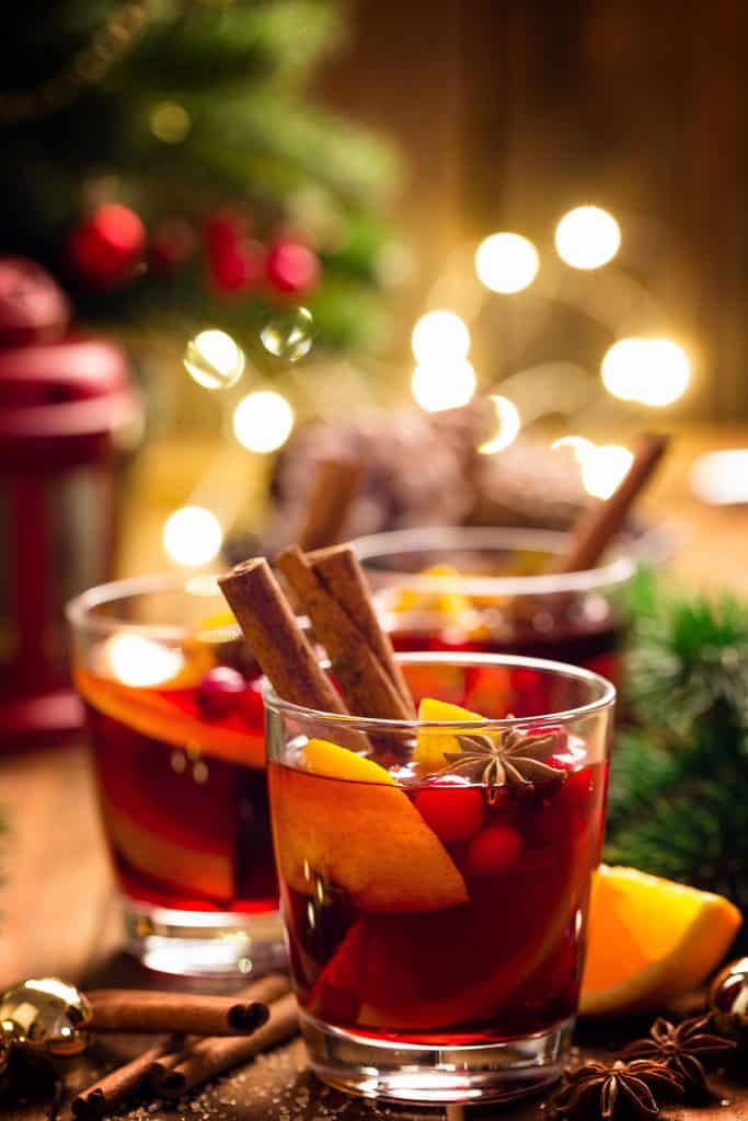 two glasses of Christmas Punch with festive lights in the background