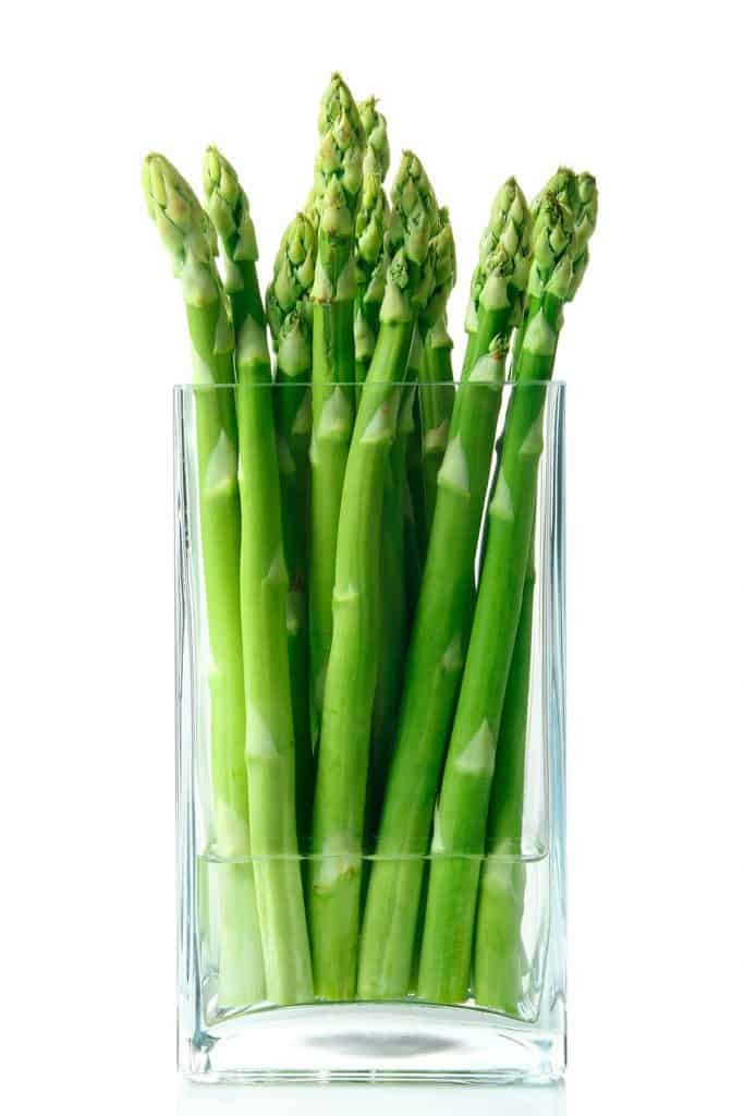 asparagus standing up in a glass with water