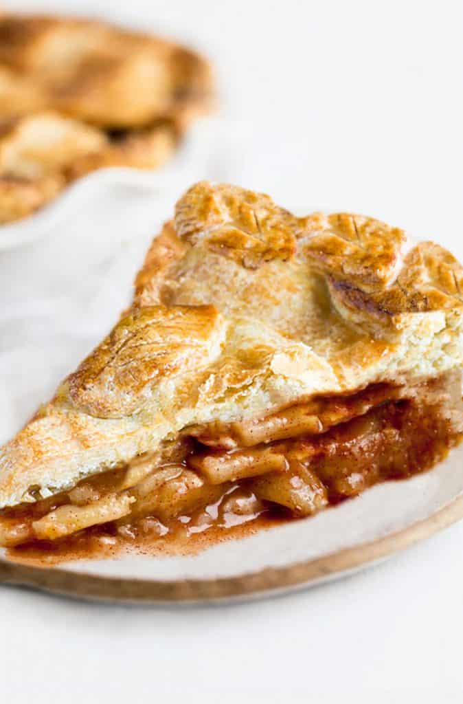 A slice of apple pie with a golen applie pie filling