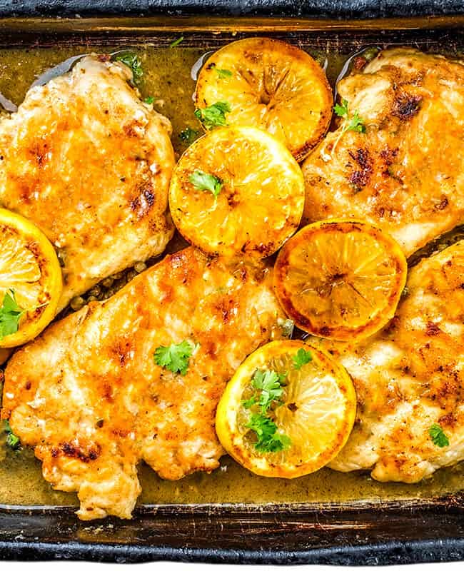 Chicken Francaise on a serving platter garnished with lemon slices