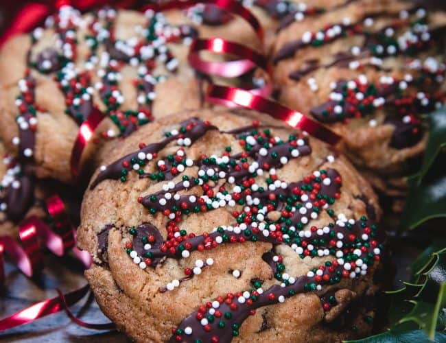 a stack of chocolate chip cookies decorated with christmas sprinkles