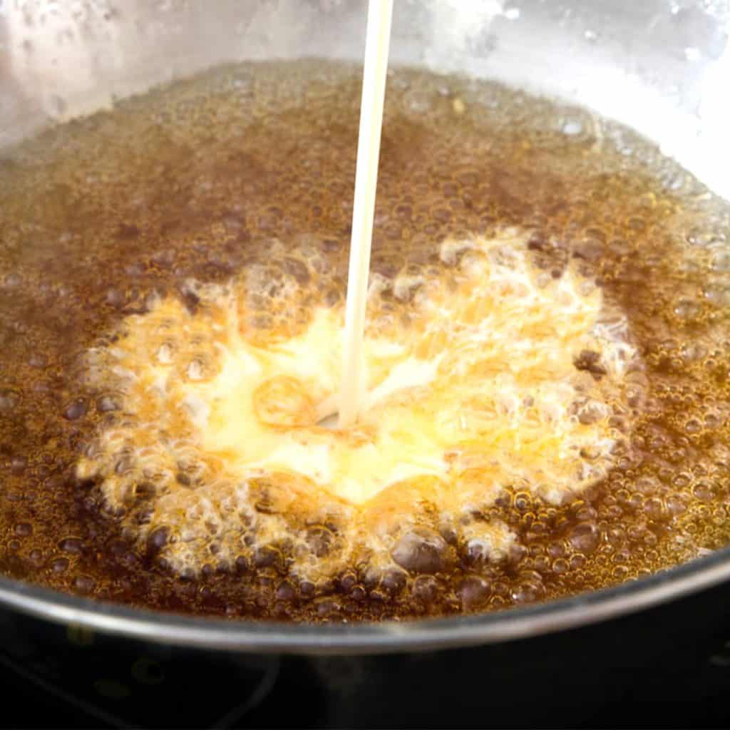 Cream being poured into the bubbling sugar mixture