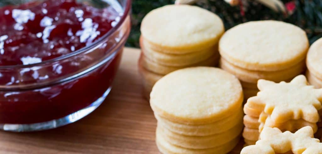 a jar of jam next to cookies