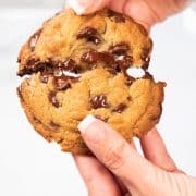 a chocolate chip cookie being broken in half