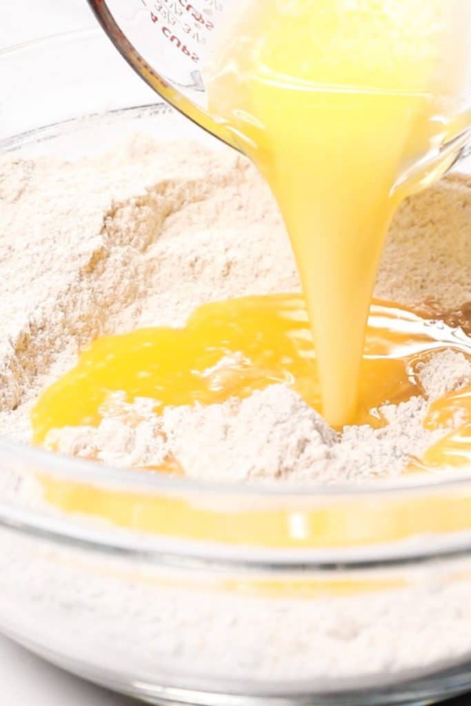 melted butter being added to the dry ingredients for cookies