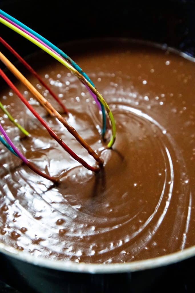chocolate frosting being mixed in a pan