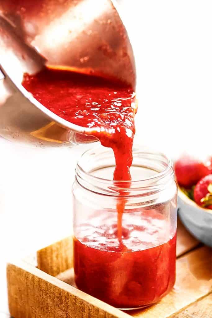 Strawberry Jam Preserves being poured into a jar