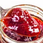 Strawberry jam being spooned out of a jar