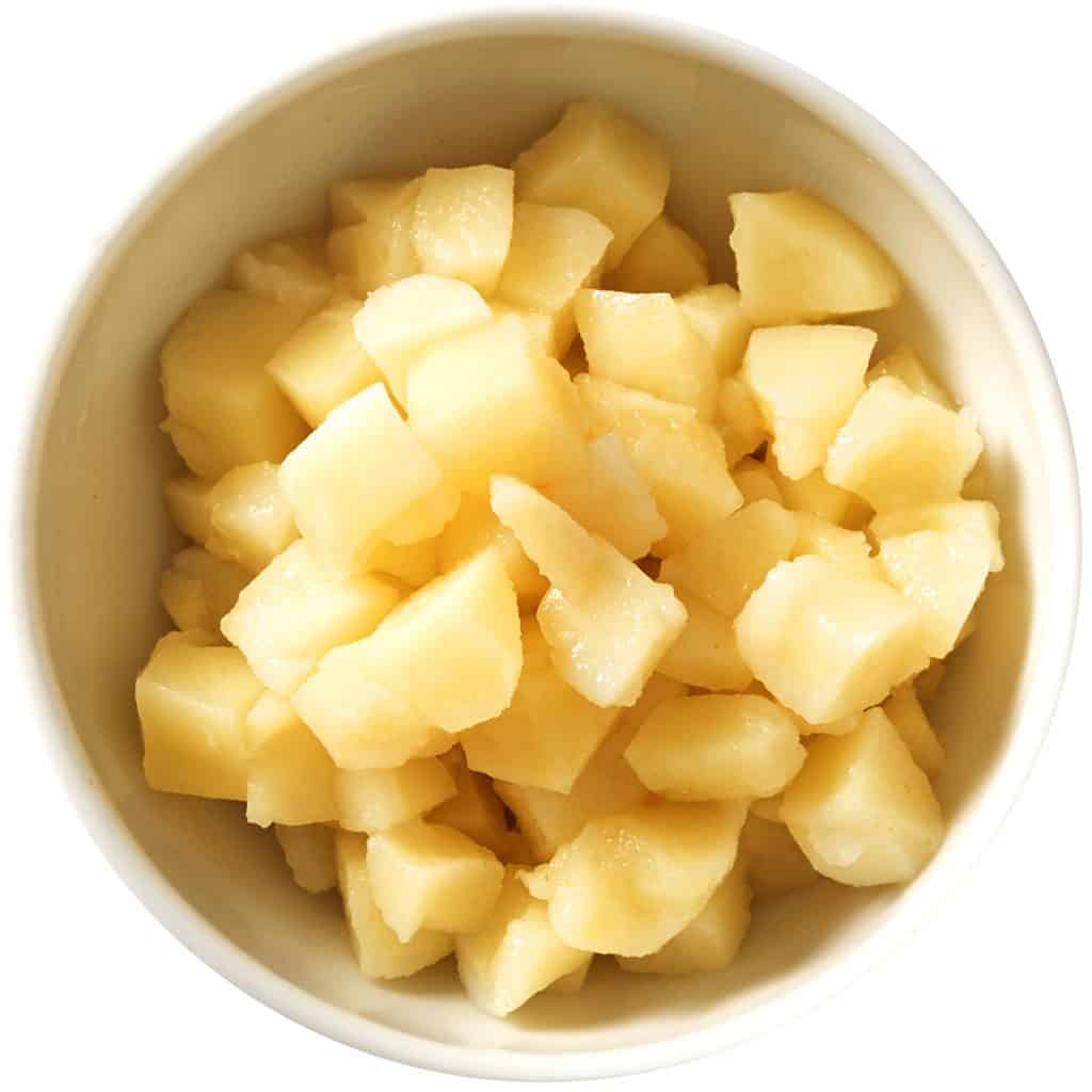 cooked potatoes in a bowl dressed with vinegar