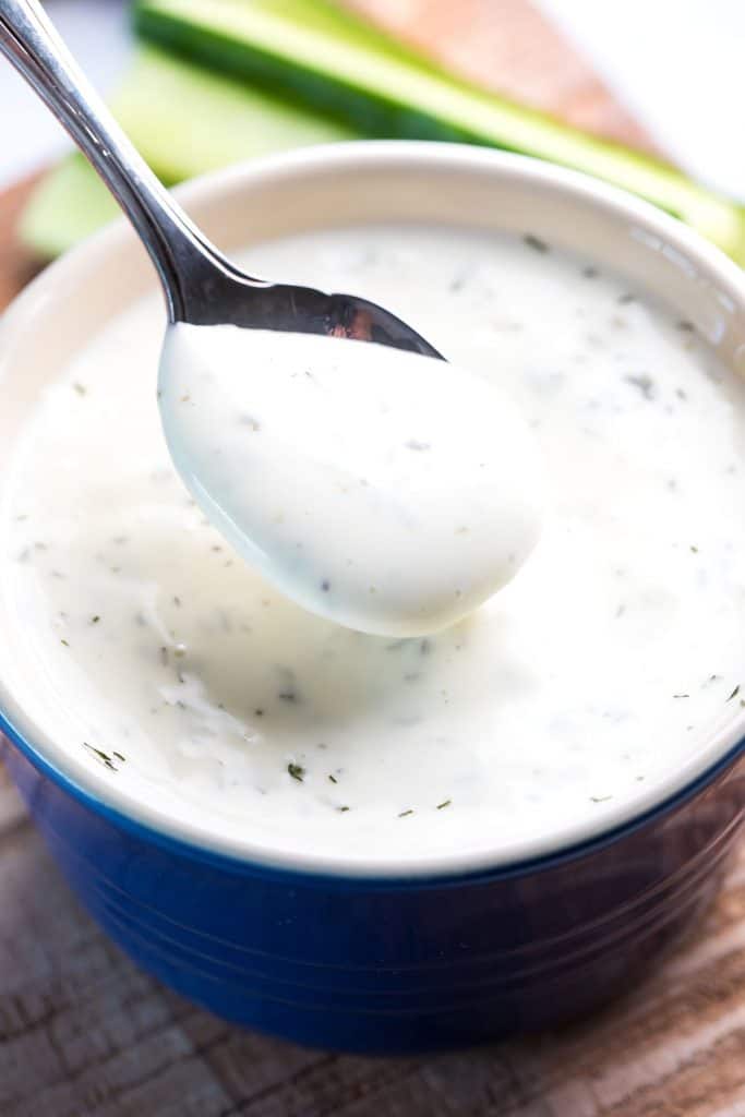 A closeup image of a spoonful of ranch dressing.