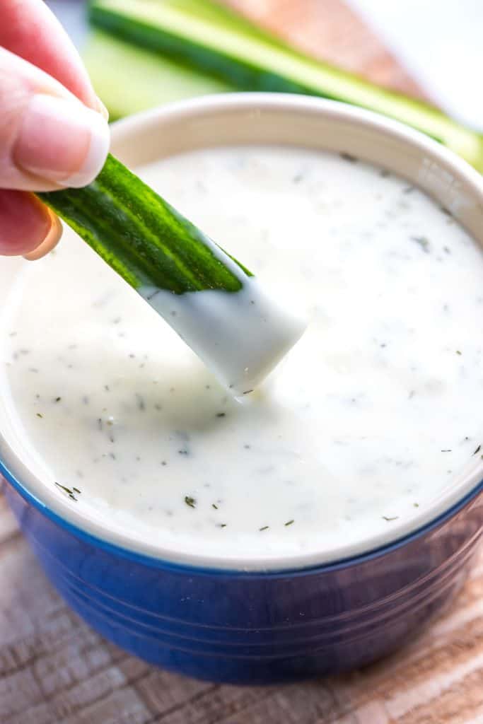 cucumber being dipped into ranch dressing