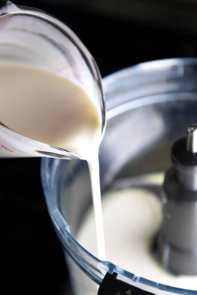 cream being poured into a mixer