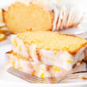 A sliced lemon pound cake with icing and lemon zest.