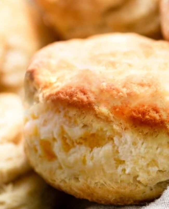 a close up of a freshly baked Buttermilk Biscuits in a baskey