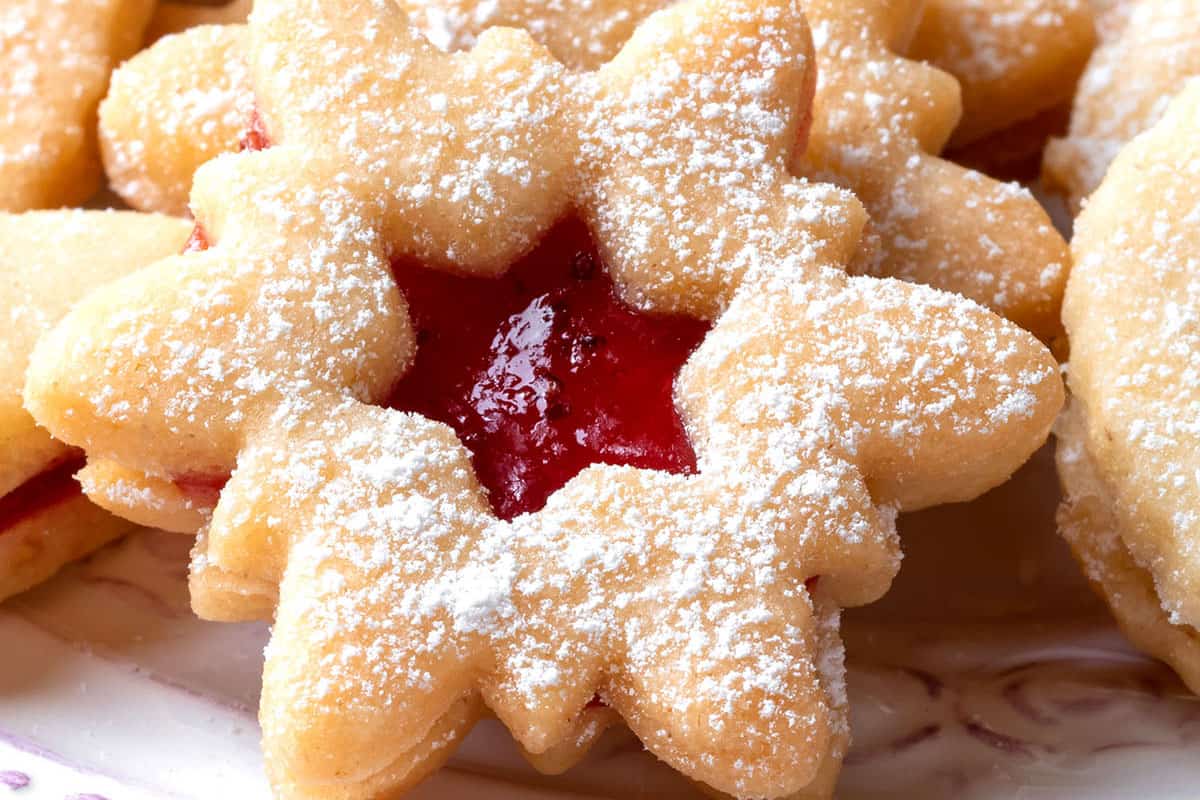 a snowflake xmas cookie filled with jam and dusted with powdered sugar