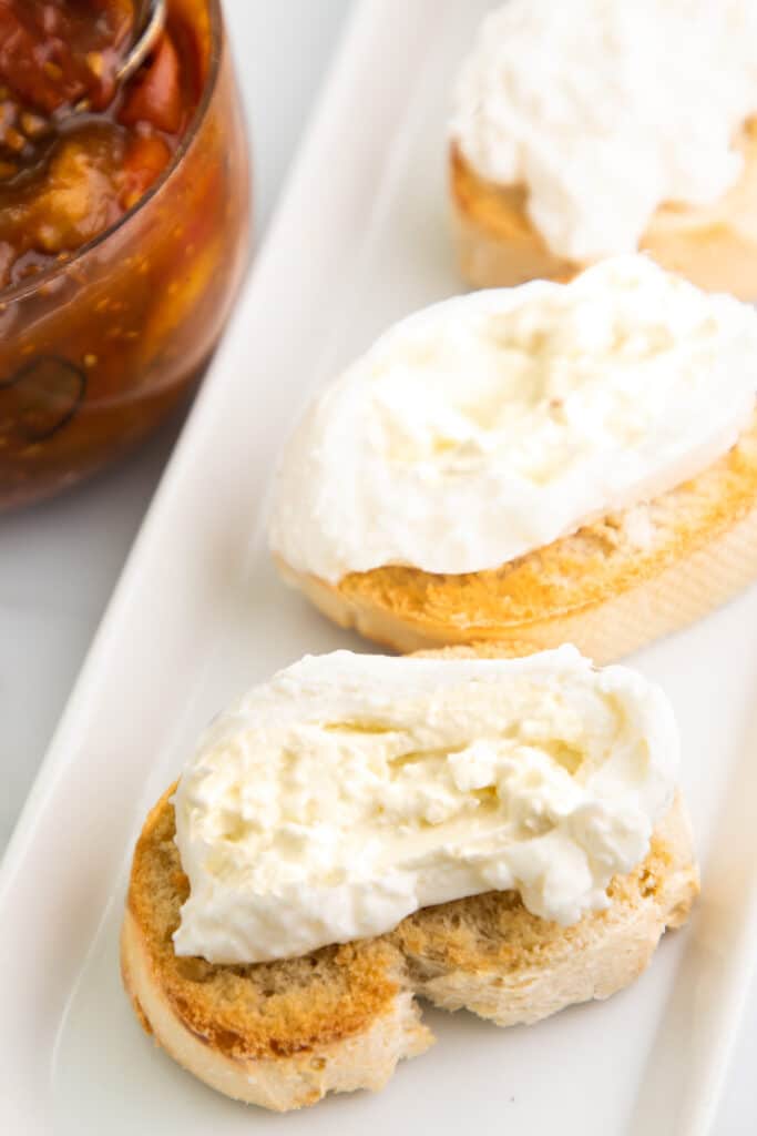 burrata cheese on top of thinly sliced, toasted Italian bread