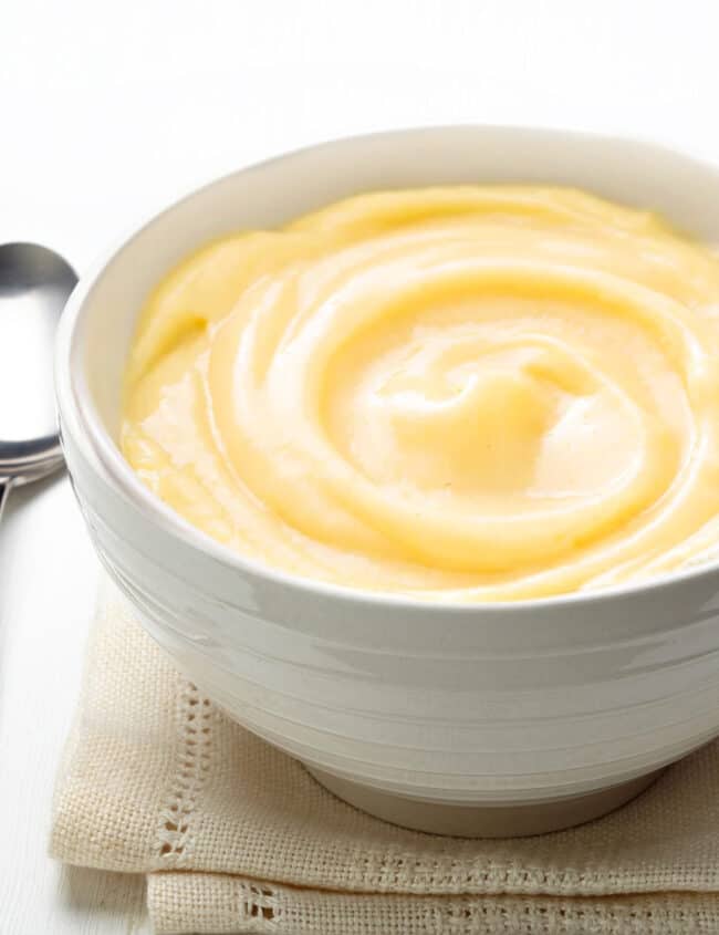 Bowl of pastry cream with a spoon to the side