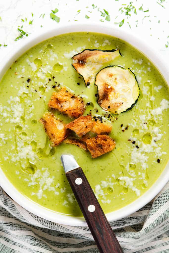 An overhead image of Zucchini Soup topped with golden croutons.