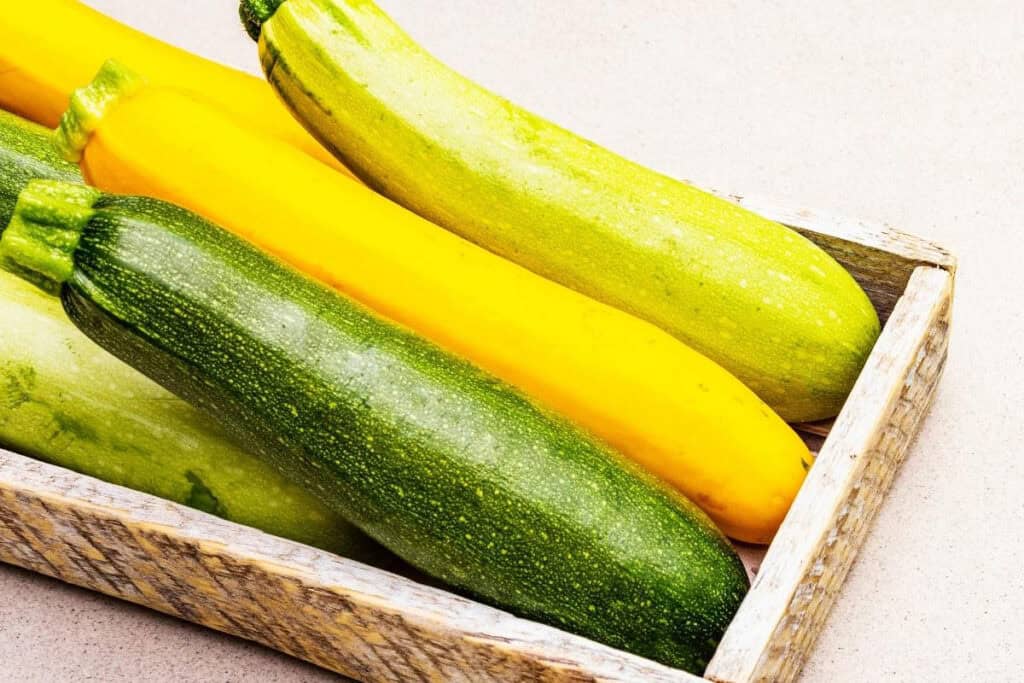 3 zucchini's in a wooden box.