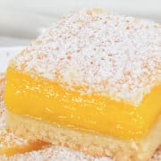 A close up image of a stack of lemon squares on a white plate.