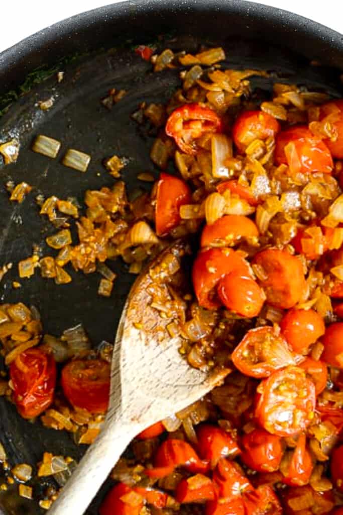 onions and cherry tomatoes cooked in a pan