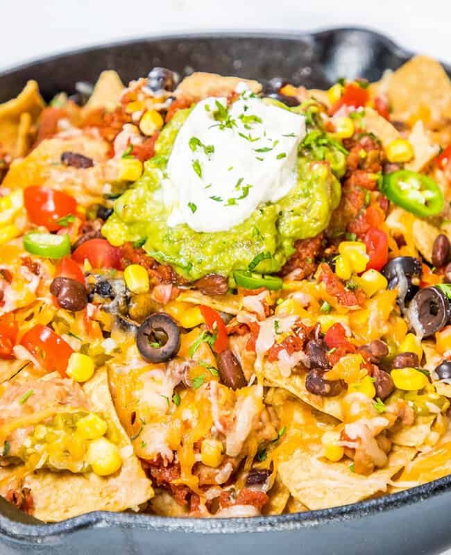 Hot nachos fresh from the oven topped with guacamole and sour cream.