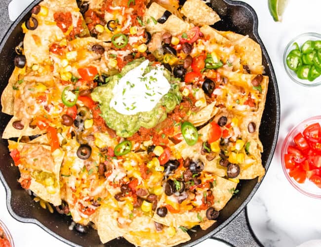 an overhead image of of a cast iron pan with nachos