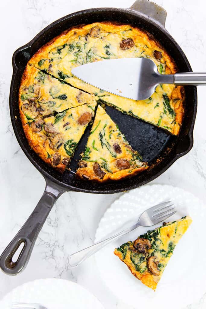 A delectable mushroom and spinach quiche nestled in a cast iron skillet