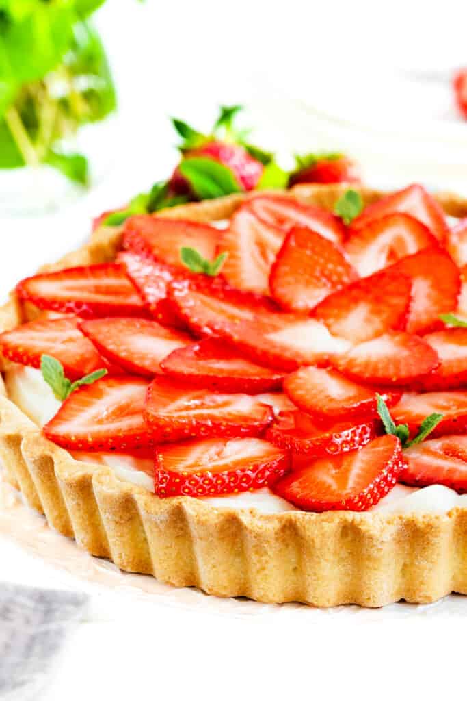 a Strawberry Tart with strawberries and mint in the background