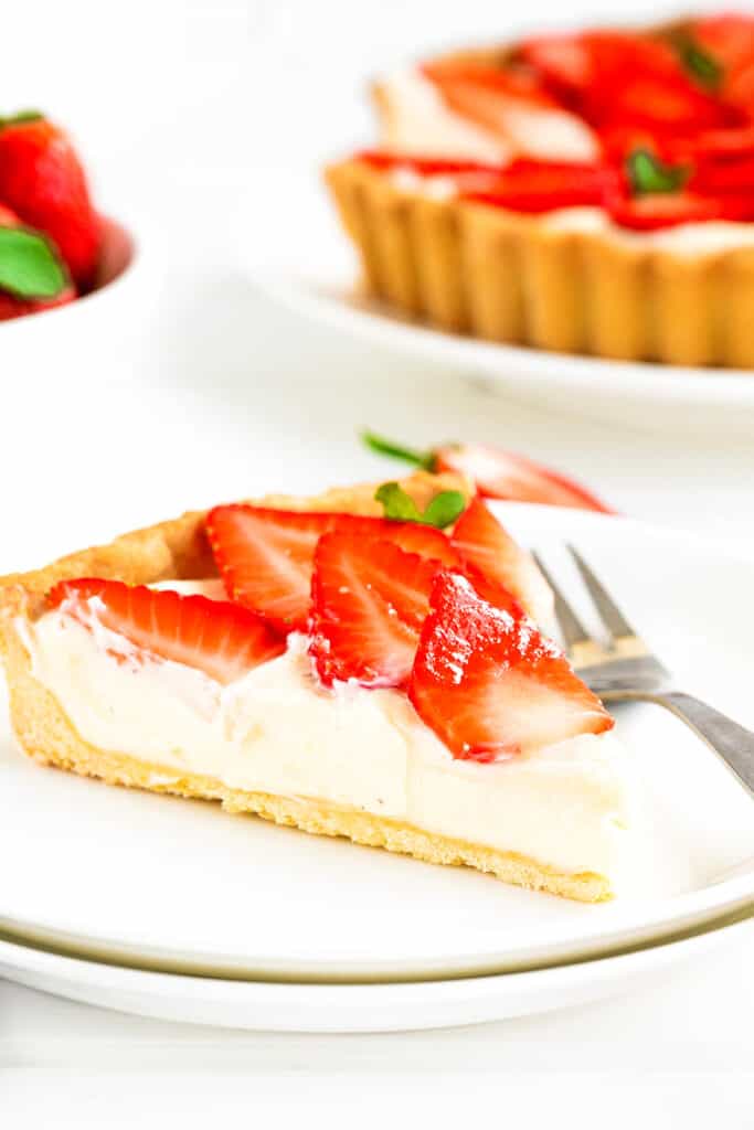 a slice of strawberry tart on a plate with a fork