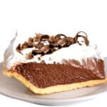 a slice of chocolate pudding pie topped with whipped cream and chocolate curls