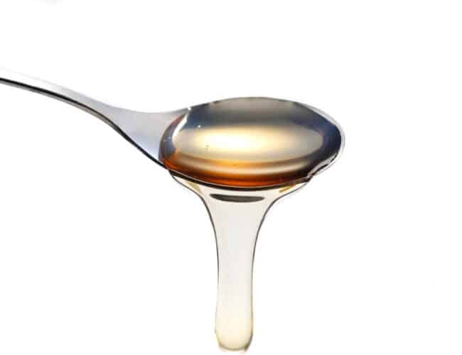 a spoon with simple syrup pouring from it