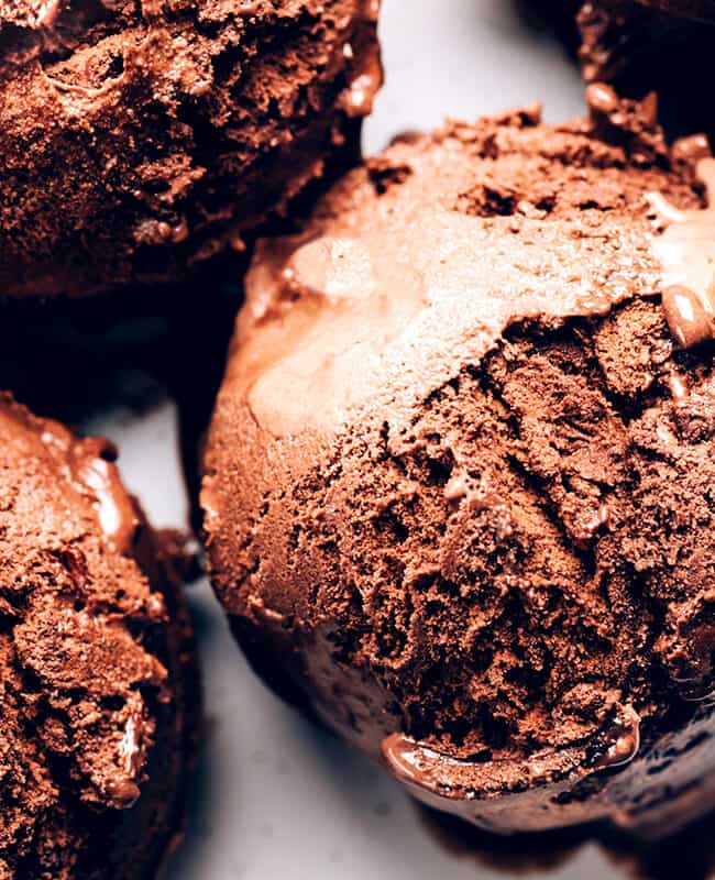 scoops of dark chocolate ice cream on a white plate