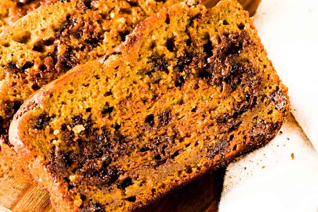 a slice of Easy Pumpkin Bread showing the melted chocolate inside the slice