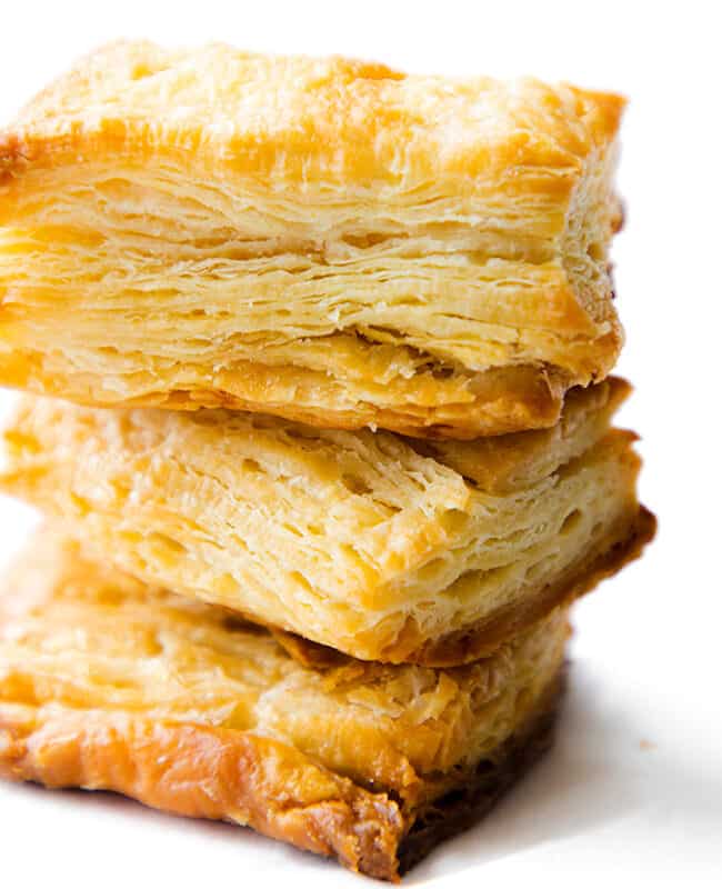 three slices of baked, golden rough puff pastry