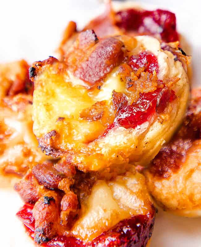 A plate of 4 baked brie bites with a white background.