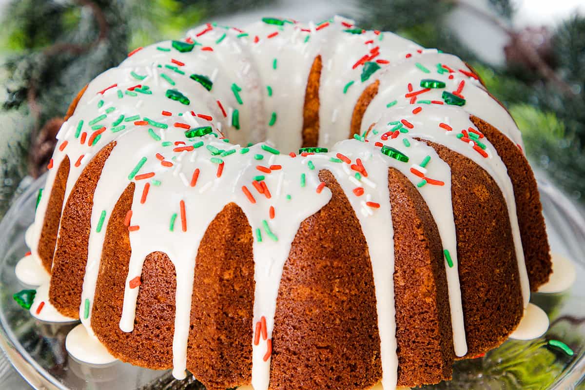 an eggnog bundt cake topped with glaze and holiday sprinkles