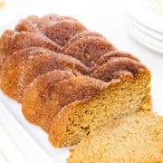 a applesauce bread on a serving dish with a slice cut