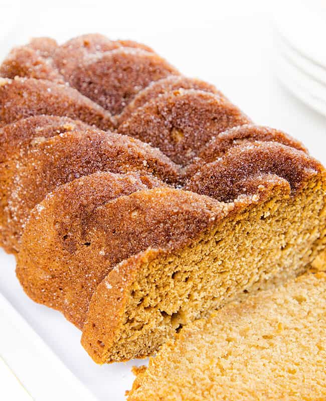 a applesauce bread on a serving dish with a slice cut