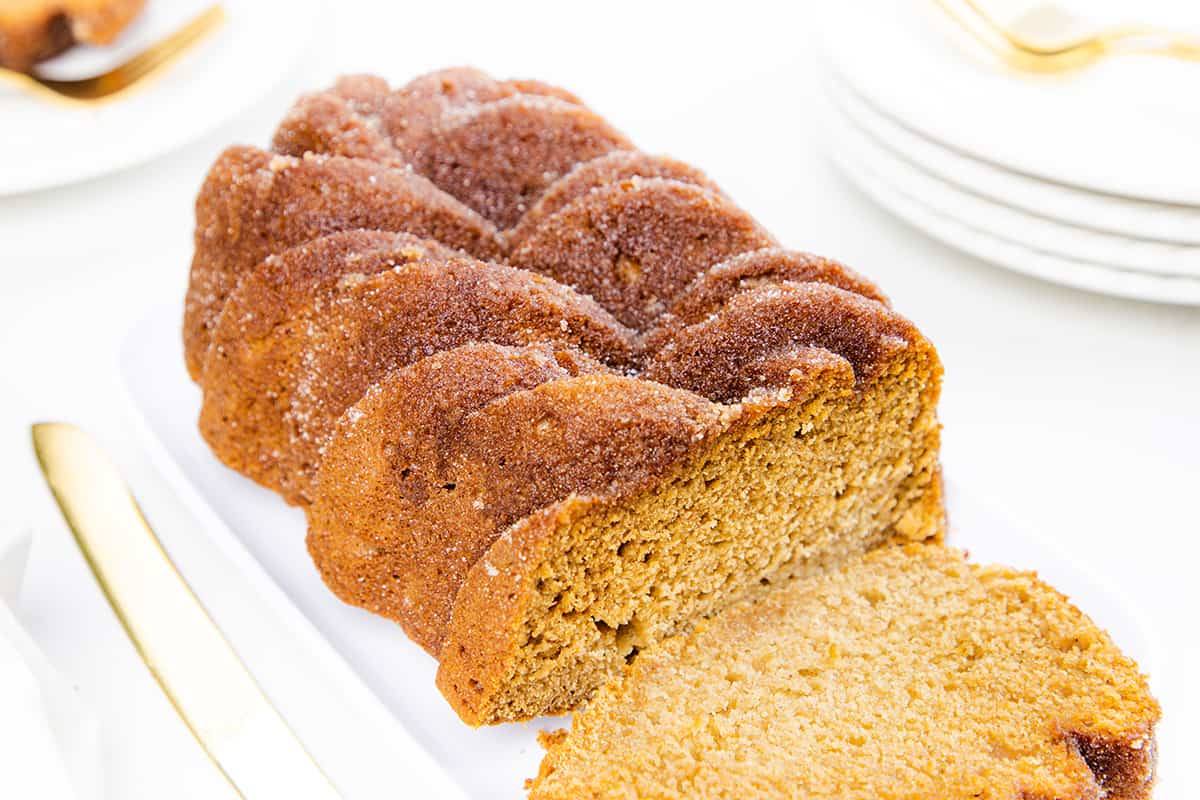 a applesauce bread on a serving dish with a slice cut