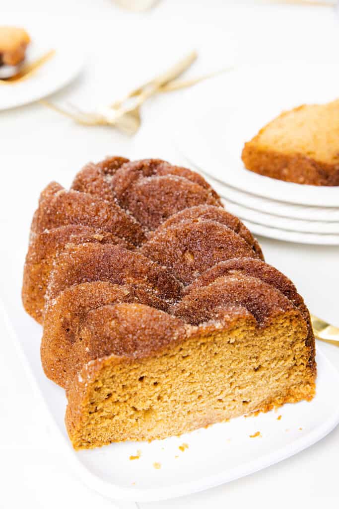 a loaf of Applesauce Bread on a platter with a slice removed