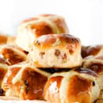 a pile of fresh hot cross buns with a clear glaze on top